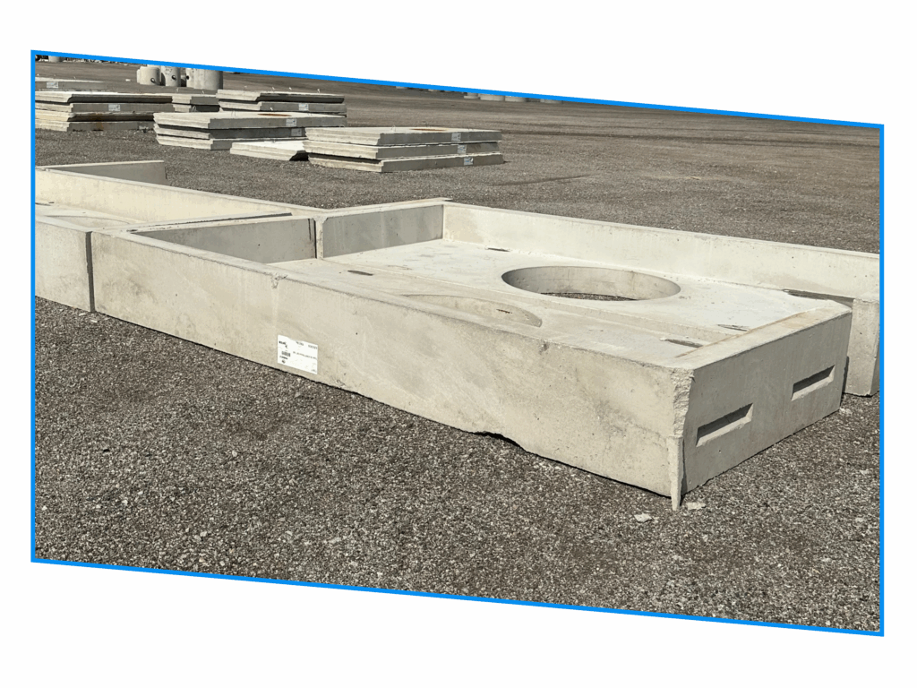 Rectangular concrete slab with a circular hole, placed on gravel near other concrete pieces.